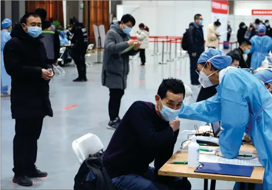  ?? Photo: Li Hao/ GT ?? Medical workers check out people’s health condition before vaccinatio­n at a temporary vaccinatio­n site in Chaoyang district, Beijing, on Monday.