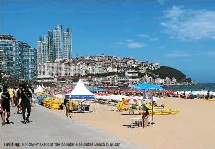  ??  ?? Inviting: Holiday-makers at the popular Haeundae Beach in Busan.