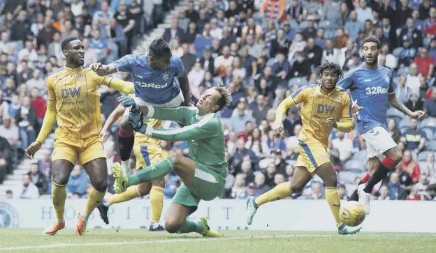  ?? PICTURE: ROBERT PERRY/PA ?? Colombian striker Alfredo Morelos gets to the ball ahead of Wigan goalkeeper Chris Walton to give Rangers the lead in yesterday’s Ibrox friendly.