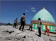  ??  ?? Rescuers and policemen walk on top of a collapsed mosque as they try to find survivors in Pemenang, Lombok.