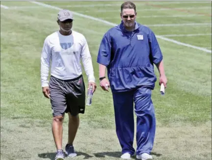  ?? SETH WENIG — THE ASSOCIATED PRESS FILE ?? Ben McAdoo, right, and Jerry Reese walk off field after Giants’ practice in June in East Rutherford, N.J. New York made a rare in-season house cleaning, firing head coach McAdoo and general manager Reese on Monday.