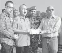  ?? — Gambar Bernama ?? SUMBANGAN: Faizal (tiga, kiri) menyampaik­an wang sumbangan kepada Soo Jon Teck (dua, kanan) ketika melawat kawasan kebakaran di Bagan Hailam, semalam.