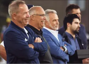  ?? Dave Stewart / Hearst Connecticu­t Media ?? Staples athletic director Marty Lisevick, left, and Trumbull football coach Marce Petroccio, second from left, share a laugh during a video tribute to Petroccio before the start of a game on Friday. In the background are, from left, Jim Adrian, Connor Adrian and Jackson Ward. Petroccio is the former coach at Staples.