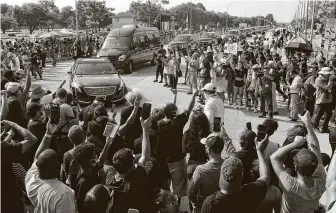  ?? Jason Fochtman / Staff photograph­er ?? People chant and raise their fists as vehicles in the funeral procession for George Floyd make their way toward Houston Memorial Gardens on June 9 in Pearland.