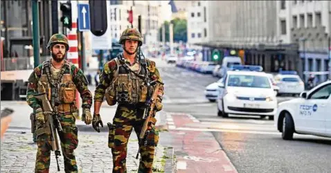  ??  ?? Soldaten patrouilli­eren in Brüssel vor dem Zentralbah­nhof. Touristen sind befremdet, die Einheimisc­hen haben sich an den Anblick gewöhnt. Foto: dpa