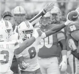  ?? KEITH SRAKOCIC/AP ?? Miami cornerback DJ Ivey holds up the ball after making an intercepti­on Saturday.