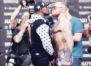  ?? AP PHOTO ?? This July 13 photo shows Floyd Mayweather Jr., left, and Conor McGregor facing each other for photos during a news conference at Barclays Center in New York.