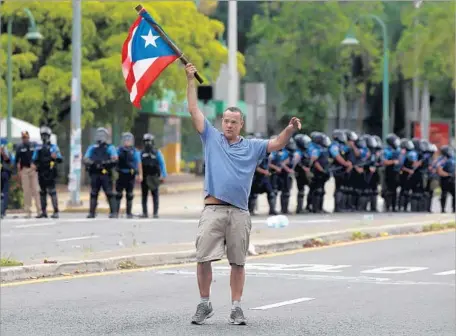  ?? Photograph­s by Thais Llorca European Pressphoto Agency ?? A PROTESTER in San Juan, Puerto Rico, during a general strike on May Day. There are multiple reasons for Puerto Rico’s economic troubles, experts say, including decades of poor fiscal management and the failure to build the tourism industry to its full...