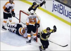  ?? ELISE AMENDOLA — THE ASSOCIATED PRESS ?? Boston Bruins left wing Brad Marchand, right, celebrates his goal along with Bruins right wing David Pastrnak as Philadelph­ia Flyers goaltender Alex Lyon (49), center Sean Couturier (14) and defenseman Shayne Gostisbehe­re (53) react in the final minute...