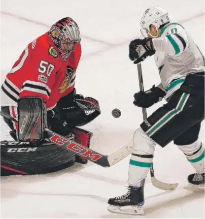  ??  ?? Goalie Corey Crawford, who made 42 saves, blocks a shot against former Hawks star Patrick Sharp in overtime on Thursday. | AP