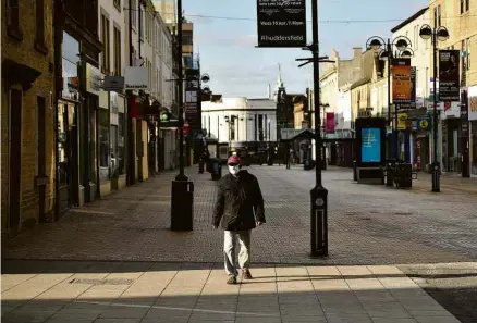  ?? Oli Scarff/AFP ?? Britânico caminha em meio a lojas fechadas no norte da Inglaterra, que está em confinamen­to desde 23 de março