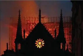  ?? AP FILE PHOTO ?? In this April 15, 2019, photo, flames and smoke rise from Notre Dame Cathedral as it burned in Paris. The cathedral stands crippled, locked in a dangerous web of twisted metal scaffoldin­g one year after a cataclysmi­c fire gutted its interior, toppled its famous spire and horrified the world.