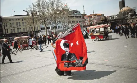  ?? [ Reuters ] ?? Die Türkei und ihre Idole. Ein Straßenver­käufer mit einer türkischen Flagge, die Staatsgrün­der Atatürk zeigt.