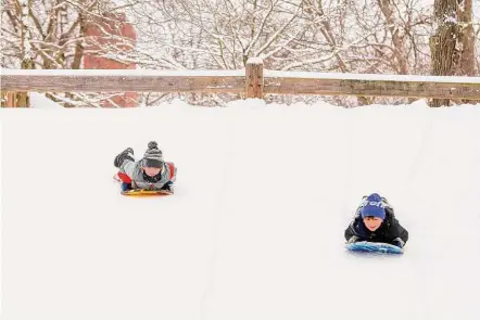  ?? Patrick Sikes/For Hearst Connecticu­t Media ?? Brothers Tucker and Luke Hariton, of Norwalk, sled down a hill at Wolfpit Elementary School in Norwalk Tuesday.