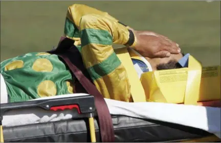  ?? MIKE GROLL — THE ASSOCIATED PRESS FILE ?? In this file photo, jockey Edgar Prado is taken to an ambulance after falling from Admiral Bird at the conclusion of the seventh race at Saratoga Race Course in Saratoga Springs, N.Y. Doctors with experience treating concussion­s among jockeys consider...