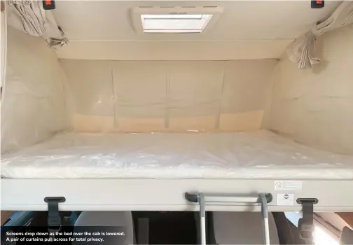  ??  ?? Screens drop down as the bed over the cab is lowered. A pair of curtains pull across for total privacy.