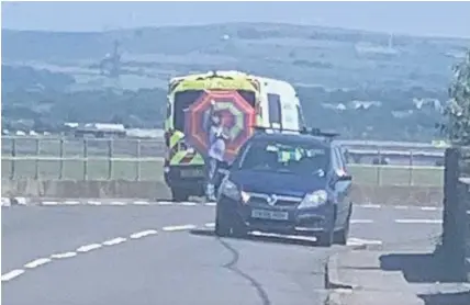  ?? EMILY MABBETT ?? A man holding a parasol up outside a GoSafe mobile speed camera van in Penclawdd, Swansea