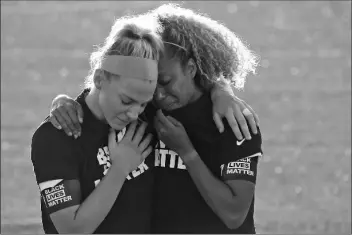  ?? ASSOCIATED PRESS ?? CHICAGO RED STARS’ JULIE ERTZ (LEFT) holds Casey Short after players for their team knelt during the national anthem before an NWSL Challenge Cup soccer match against the Washington Spirit at Zions Bank Stadium on Saturday in Herriman, Utah.