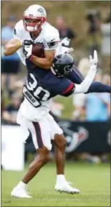  ?? BRETT COOMER/HOUSTON CHRONICLE VIA AP ?? New England Patriots wide receiver Chris Hogan (15) leaps up over Houston Texans cornerback Kevin Johnson (30) to catch a pass during a joint NFL football practice, Tuesday.