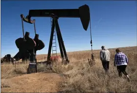  ?? HELEN H. RICHARDSON — THE DENVER POST ?? Homeowners Ron and Cindy Mccormick walk near a pump jack and other abandoned oil and gas equipment on their land in Hudson, Colorado on Feb. 28, 2024.