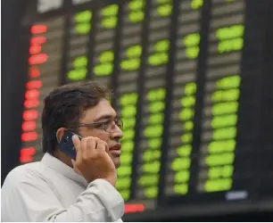  ?? — AFP ?? A stockbroke­r watches share prices during a trading session at the Pakistan Stock Exchange in Karachi. Pakistan was upgraded by the MSCI Emerging Markets Index on June 1.