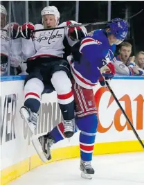  ?? PAUL BERESWILL/ GETTY IMAGES ?? Anton Stralman of the Rangers sends Jason Chimera of the Capitals flying into the boards in the third period in Game 6 of the Eastern Conference quarter- finals Sunday. Rangers won 1- 0.