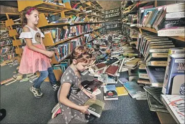  ?? Irfan Khan Los Angeles Times ?? TWIN SISTERS Zoe, left, and Tala Pineda arrive Friday to help clean up books from Ridgecrest Branch Library that were tossed in Thursday’s quake. Their mother is Shalyn Pineda, a regional library supervisor.