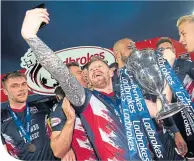  ??  ?? Michael Gardyne takes a selfie with the SPFL Championsh­ip trophy on Friday night