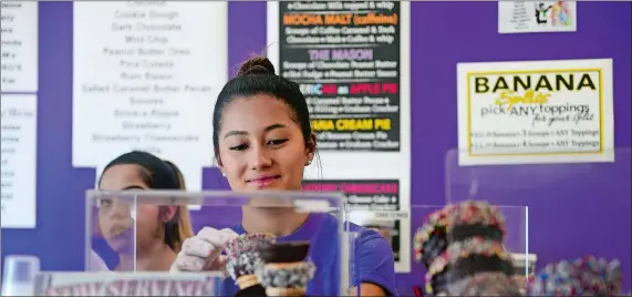  ?? SARAH GORDON/THE DAY ?? Employee Hannah Scott restocks cones at Berry’s Ice Cream &amp; Candy Bar last week. The shop recently reopened in a bigger space at 90-B Bank St. in New London.