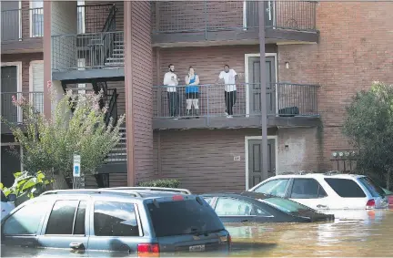  ?? SCOTT OLSON/GETTY IMAGES ?? Residents of an apartment complex in Houston could only wait and watch on Wednesday as flood waters persist across much of the city. Hurricane Harvey roared into Texas five days ago and has dumped nearly 50 inches of rain in and around Houston since.