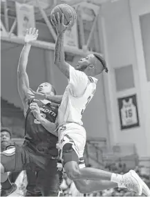  ?? Yi-Chin Lee / Houston Chronicle ?? Rice sophomore guard Ako Adams, right, goes hard to the basket against Charlotte guard Jon Davis, left, during the second half, when the Owls made a late run to seal a victory Saturday.