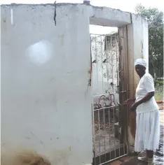  ??  ?? Mrs Rukuni stands beside one of the huts which was mysterious­ly razed by fire