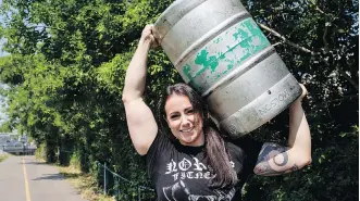  ?? JEFF $ MCINTOSH ?? Allison Lockhart, Canada’s strongest woman, who will be competing this weekend at the Calgary Stampede, carries a beer keg while training.