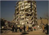  ?? EMRAH GUREL — THE ASSOCIATED PRESS ?? People stand by a collapsed building in Kahramanma­ras, southern Turkey, on Sunday.