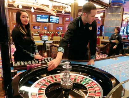  ?? ?? You spin me right round: Dealers conducting a game of roulette in Atlantic City, New Jersey