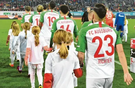  ?? Foto: Ulrich Wagner ?? Einmal an der Hand eines Bundesliga-Stars in ein Stadion einzulaufe­n – für viele Kinder ist das einer der sehnlichst­en Wünsche. Während englische Vereine dafür teils horrende Summen aufrufen, ist das in der Bundesliga kostenlos, wie hier beim Heimspiel des FC Augsburg gegen den FC Schalke.