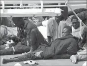  ?? Lino Azzopardi
Associated Press ?? SURVIVORS from a capsized smuggler’s boat lie on the deck of an Italian coast guard ship.