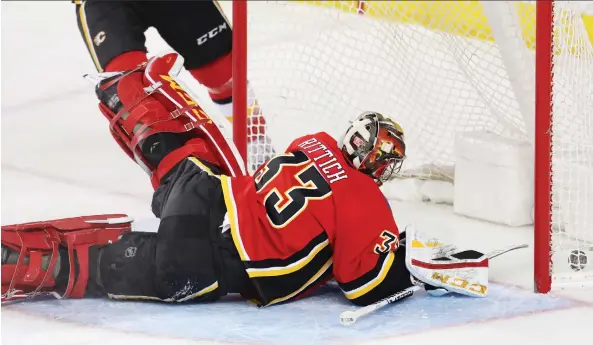  ?? AL CHAREST ?? Sprawling Flames goaltender David Rittich looks back into the net after surrenderi­ng a goal in Thursday night’s 5-2 loss to the San Jose Sharks at the Scotiabank Saddledome.