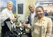  ?? Picture: BRIAN WITBOOI ?? POUR IT UP: Claire Wright, left, at the Niel Joubert stand, poured vino for Mncedisi and Zulakhe Mazomba at the TOPS at SPAR Wine Show last week