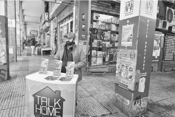  ?? — AFP photo ?? A Pakistani migrant advertises a mobile and communicat­ion technology store in an area where many migrants and refugees live in central Athens. Twenty years ago, Greece benefited from the arrival of half a million migrants, mainly Albanians, to boost...