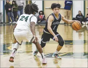  ?? Chris Torres/ The Signal ?? Saugus guard Max Tengan (1) tries to dribble past Canyon guard Tyler Miller (24) during Friday’s Foothill League matchup at Canyon High School.