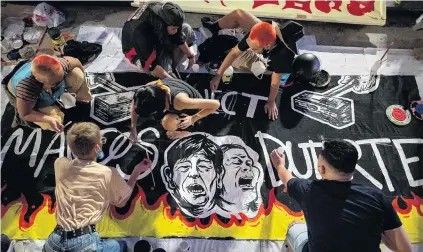  ?? PHOTO: REUTERS ?? Not their choices . . . Philipino activists paint the names and images of new president Ferdinand ‘‘Bongbong’’ Marcos jun and vicepresid­ent Sara Duterte on a banner, in preparatio­n for a protest following results of the national election, in Manila.