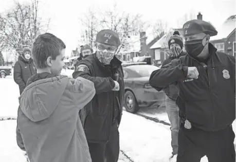  ??  ?? Wyatt Nicol, 12, of Lincoln Park gets elbow bumps after a cash gift was delivered by members of the Lincoln Park Police Department.