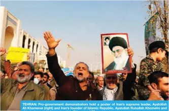  ?? —AFP ?? TEHRAN: Pro-government demonstrat­ors hold a poster of Iran’s supreme leader, Ayatollah Ali Khamenei (right) and Iran’s founder of Islamic Republic, Ayatollah Ruhollah Khomeini and shout slogans during a march in Tehran.