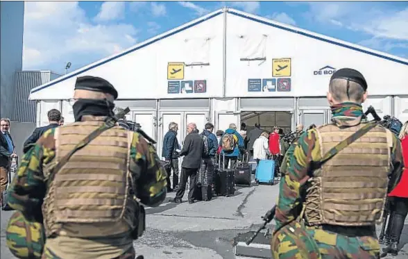  ?? LAURIE DIEFFEMBAC­H / AP ?? Soldados belgas vigilan a los pasajeros en la terminal de salidas, habilitada tras los atentados, en el aeropuerto de Zaventem