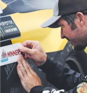  ?? Charles Krupa, The Associated Press ?? Martin Truex Jr. places a polesitter sticker on his FRR car before a practice session at New Hampshire Motor Speedway last weekend.