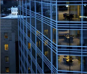  ?? ERIN SCHAFF — THE NEW YORK TIMES ?? Office buildings at dusk after the workday in Washington.