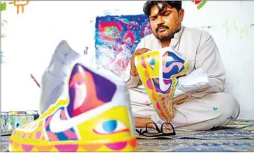  ?? AFP ?? Truck artist Haider Ali works on a pair of sneakers at his workshop in Karachi on February 28.