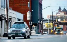  ?? Stephanie Strasburg/Post-Gazette ?? Operators ride inside one of Uber’s self-driving SUVs, along Penn Avenue in the Strip District in March 2017. Before Uber’s self-driving cars hit the road, they drive miles on a test track in Hazelwood.