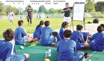  ?? ASYRAAF ?? (di papan taktik) bersama pemain di padang rumput tiruan UMS.